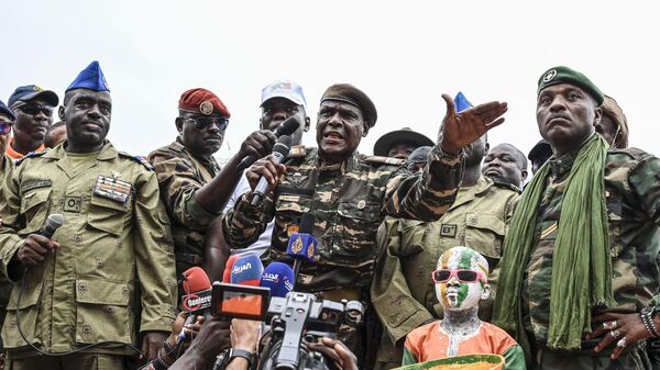 Os líderes do Conselho Nacional para a Salvaguarda da Pátria (CNSP) do Níger, coronel Ibro Bachirou Amadou (C), coronel Amadou Djibo (L) e artista do exército do Níger, Maman Sani Maigochi no estádio General Seyni Kountche, em Niamey, em 26 de agosto de 2023 - Sputnik Brasil