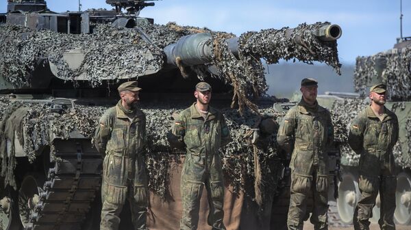 Soldados alemães da Bundeswehr (Forças Armadas) da OTAN reforçaram o batalhão de presença avançada na frente do tanque de batalha principal do Exército alemão Leopard 2A6 no campo de treinamento em Pabrade, Lituânia, em maio de 2023 - Sputnik Brasil