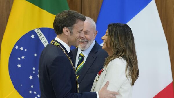 O presidente da França, Emmanuel Macron (à esquerda), cumprimenta a primeira-dama brasileira, Rosângela Lula da Silva, depois de presenteá-la com a Legião de Honra, condecoração francesa, enquanto o presidente brasileiro, Luiz Inácio Lula da Silva, observa. Palácio do Planalto, Brasília, Brasil, 28 de março de 2024 - Sputnik Brasil