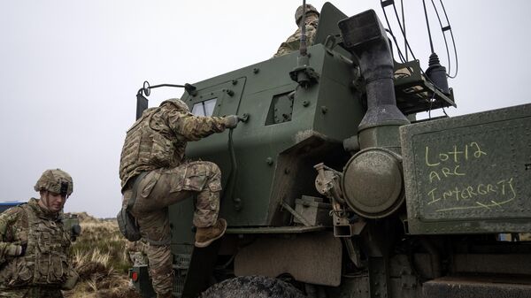 Soldados sobem em um Sistema de Foguetes de Artilharia de Alta Mobilidade (Himars, no acrônimo em inglês) M142 durante exercício militar da Frente Dinâmica liderado pelos Estados Unidos no campo de treinamento e tiro de Oksboel. Dinamarca, 30 de março de 2023 - Sputnik Brasil