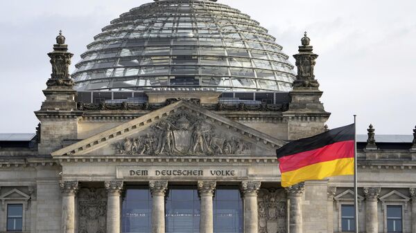 Uma bandeira nacional da Alemanha tremula em frente ao edifício do Reichstag, sede do Parlamento federal alemão Bundestag, em Berlim, Alemanha - Sputnik Brasil