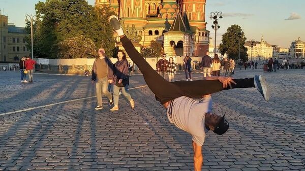 Dançarino e residente na Rússia há mais de 20 anos, o brasileiro Antonio Claudio Luz Silva, conhecido como Kakau, joga capoeira na Praça Vermelha, em Moscou, em junho de 2024 - Sputnik Brasil