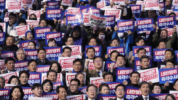 O principal líder do Partido Democrata da oposição da Coreia do Sul, Lee Jae-myung (C), grita slogans durante um comício contra o presidente Yoon Suk-yeol na Assembleia Nacional cercado de cartazes que dizem Yoon Suk-yeol deve renunciar, em Seul, Coreia do Sul, 4 de dezembro de 2024 - Sputnik Brasil