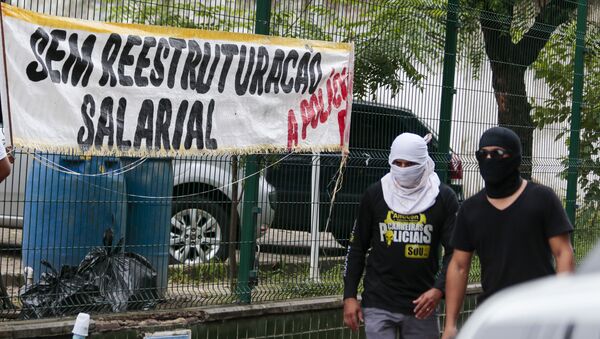 Policiais encapuzados passam por viaturas paradas durante a greve da PM no Ceará - Sputnik Brasil