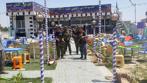 Shi'ite fighters are seen at a cafe where men, including fans of Spain's Real Madrid football club, had gathered, after an attack by gunmen in the predominately Shi'ite Muslim town of Balad, Iraq, May 13, 2016 - Sputnik Brasil