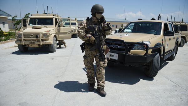 A German soldier from the NATO coalition stands guard during a visit by resolute support spokesman Brigadier General H. Cleveland outside the Shaheen 209th military corps training center in Mazar-i-Sharif on April 26, 2016 - Sputnik Brasil