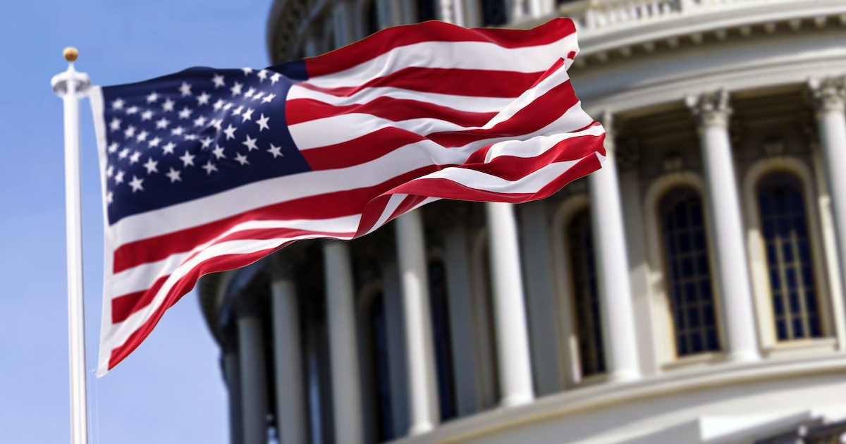 Close up image of the American flag in front of a U.S. government building