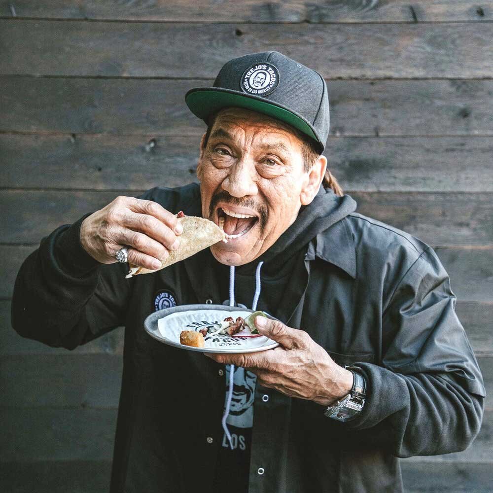 Actor Danny Trejo eats a taco at Trejo's Tacos