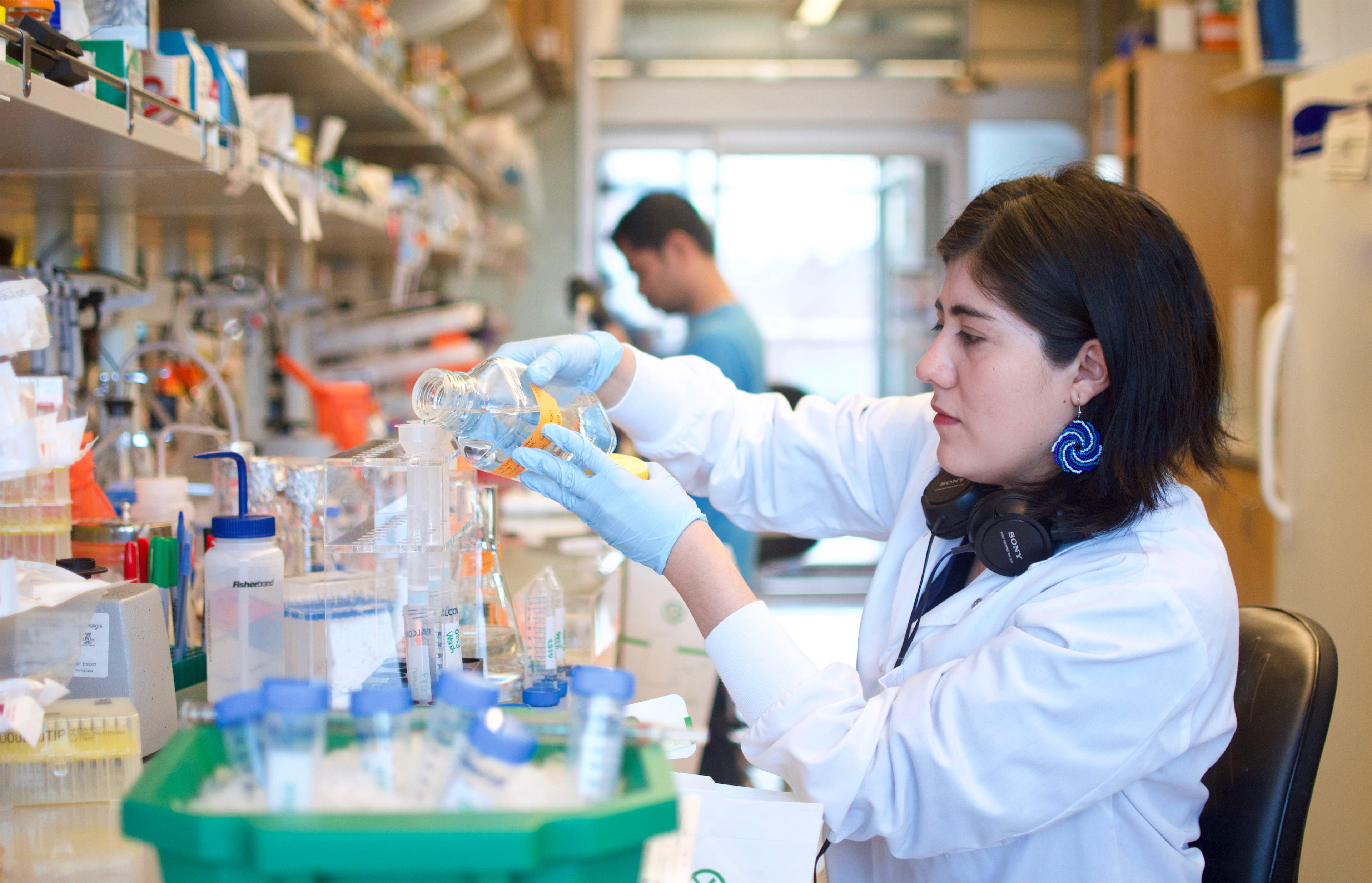 Woman pouring chemicals in lab