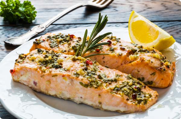 Salmon fillets with a lemon garnish, on a white plate