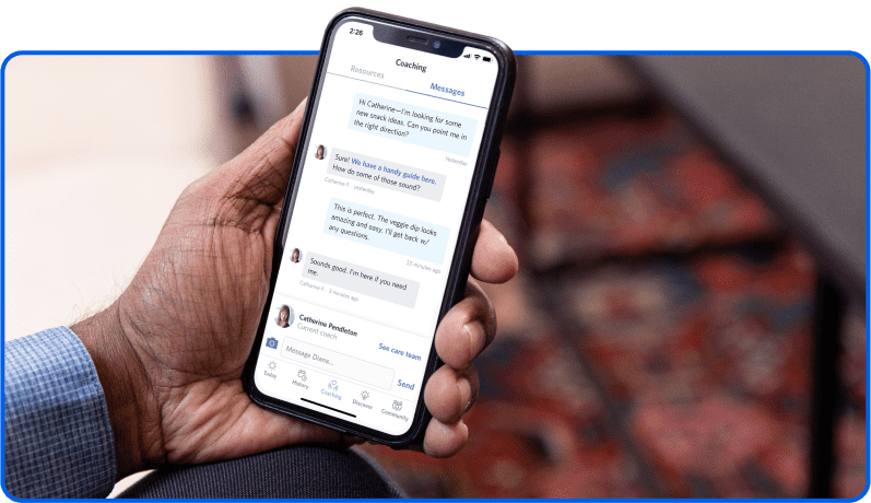 Hand holding an iPhone, showing a conversation with his Virta health coach