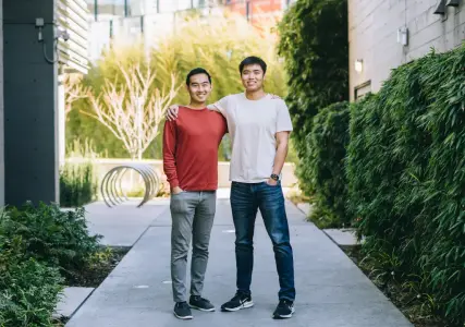 A photo of Peter Zhou and Eric Yu standing together outside.