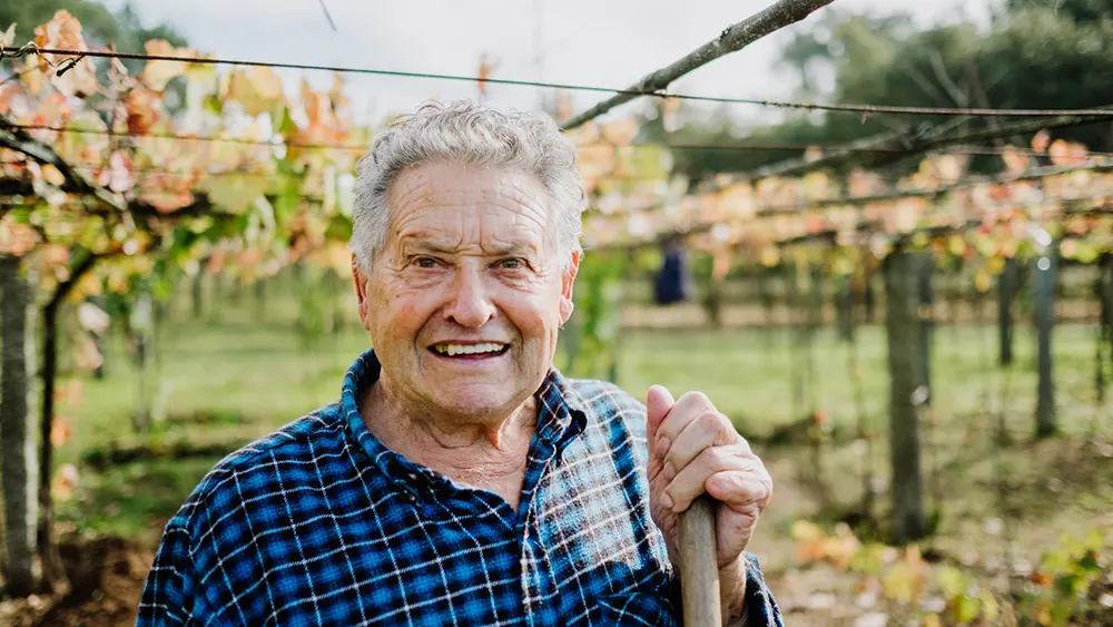 Help employees build a stable future with affordable 401k plans. Older person standing outside.