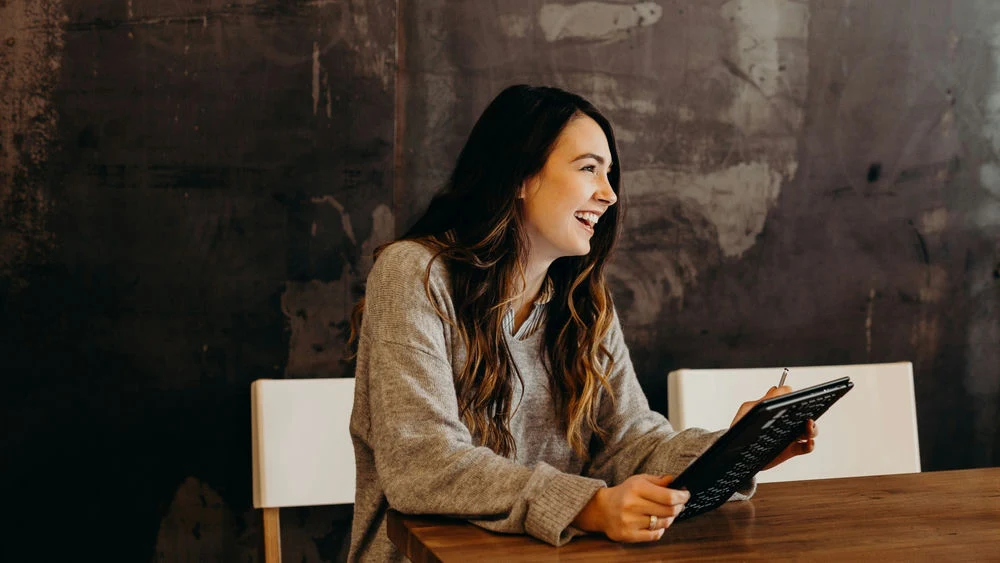 Employer uses tablet to access help with online payroll for her small business.