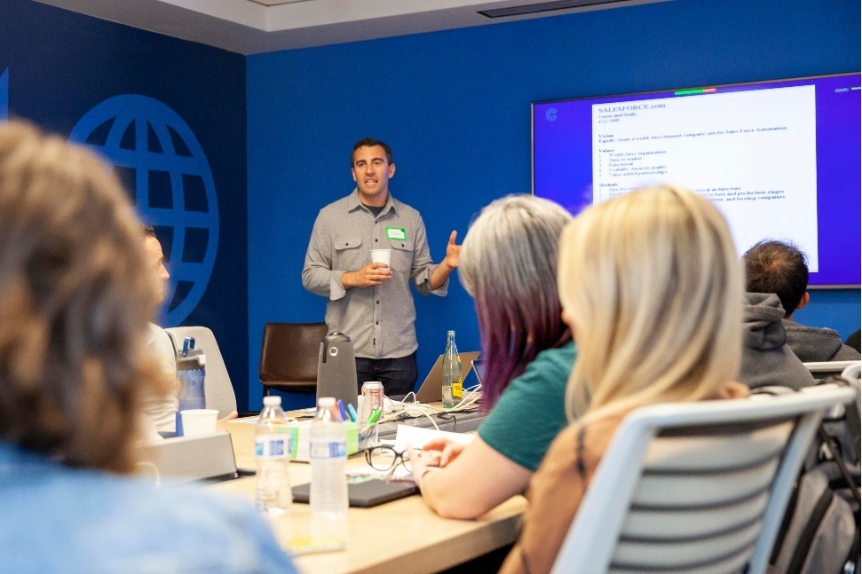 A Coalition employee presenting in front of other Coalition employees.