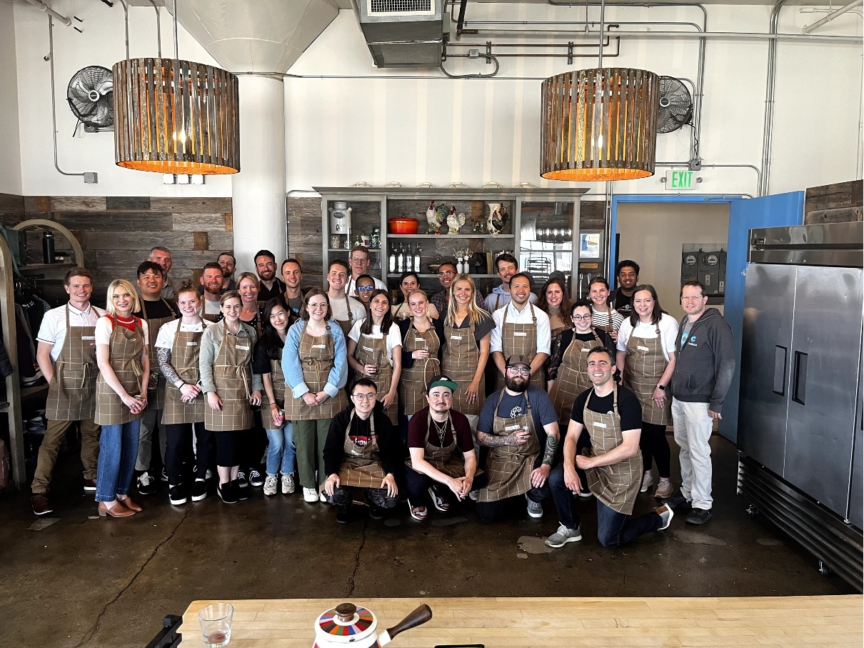 A group of Coalition employees posing at a food bank during a volunteer outing.