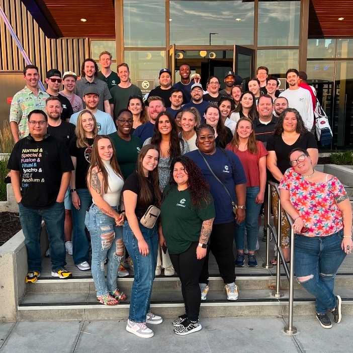 A group of Coalition employees posing in front of an office building.