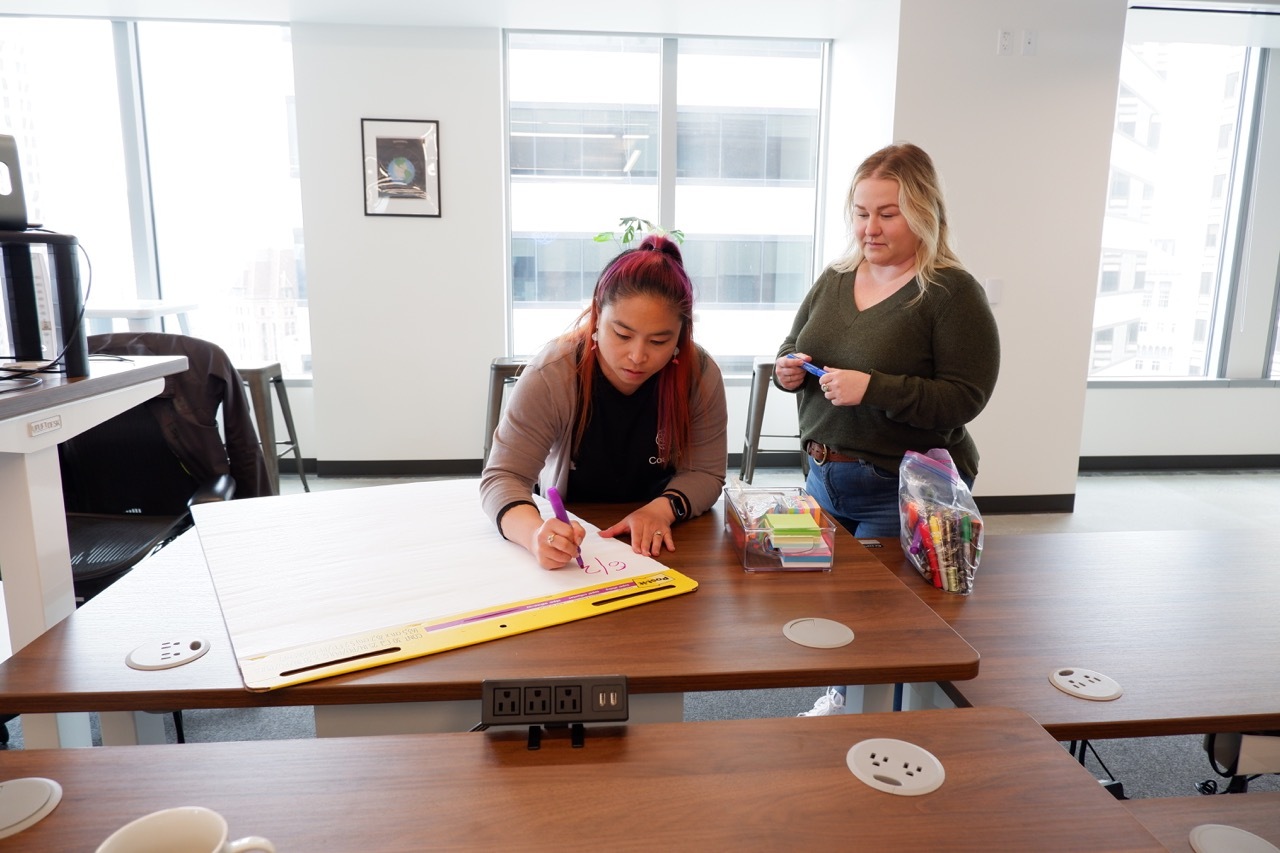 Two Coalition employees hard at work in a meeting room.