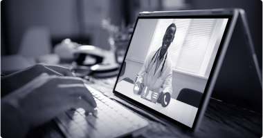 A person typing during a remote call with a doctor