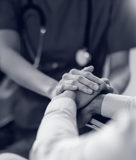 A pair of medical professionals holding hands