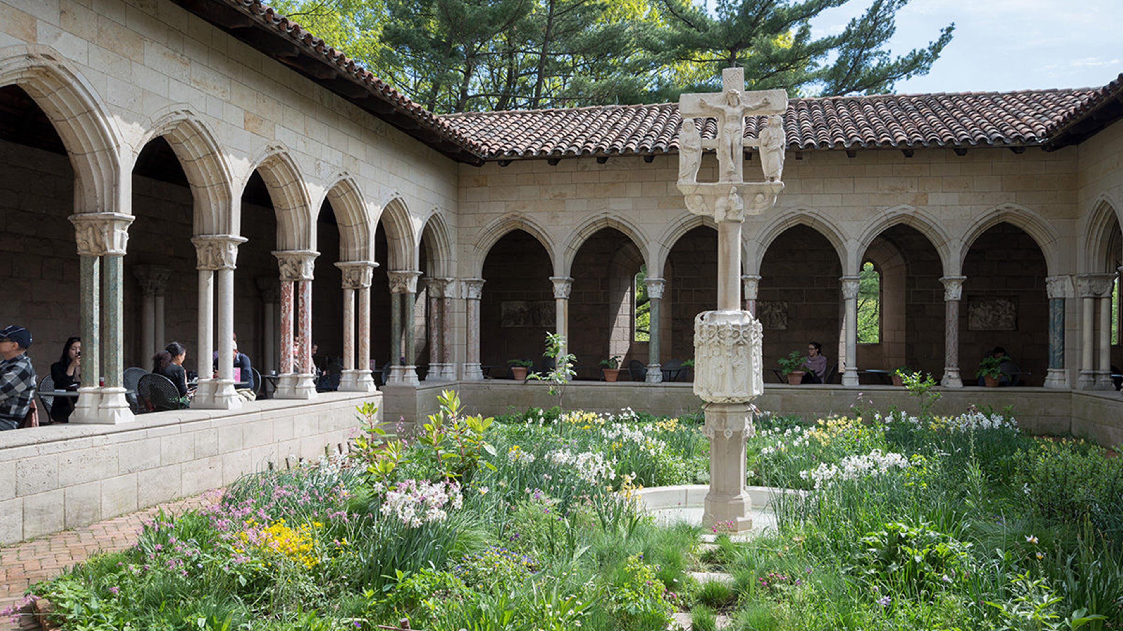 Medieval courtyard with a garden and fountain.