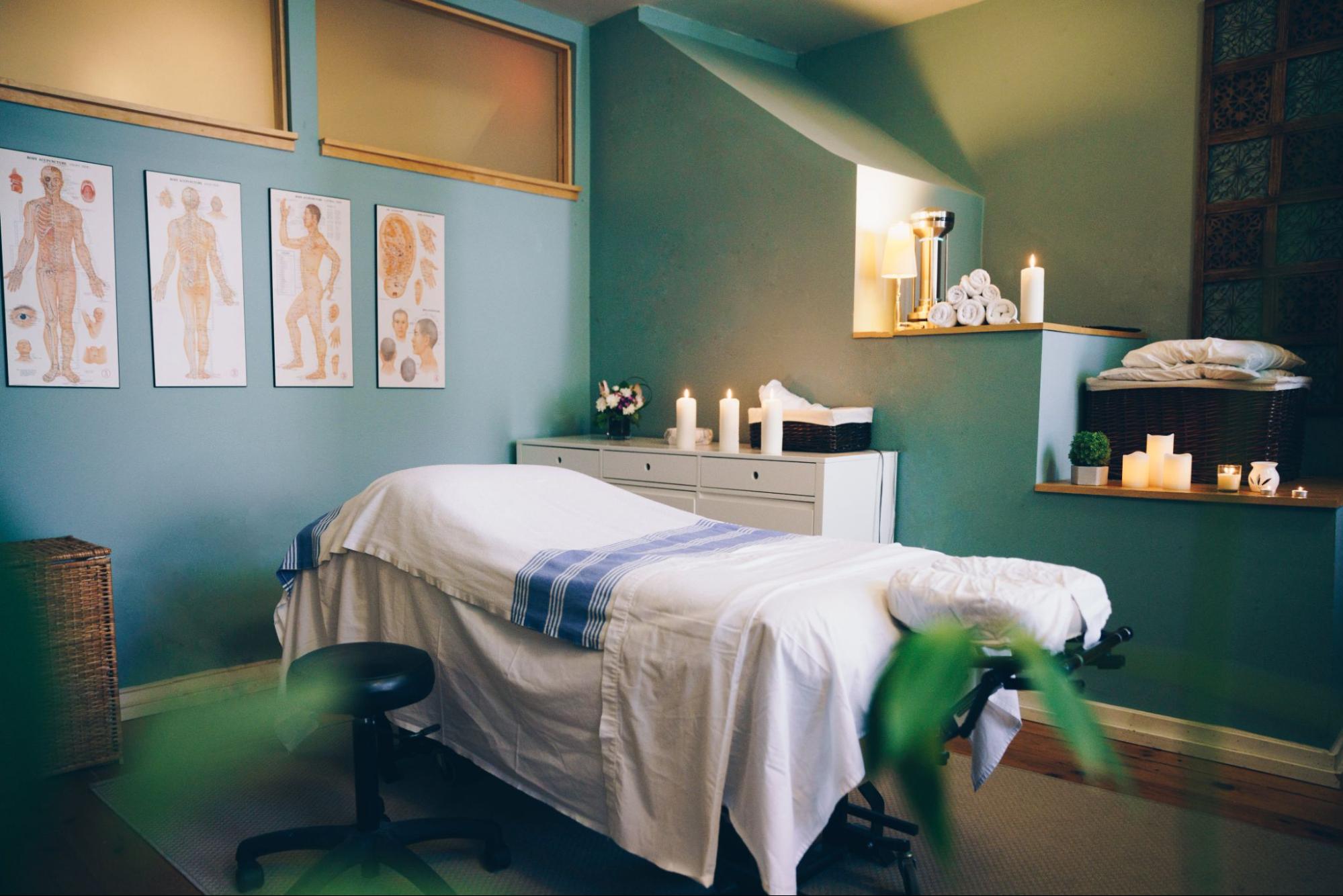 A view of a vacant spa room with a treatment table and candles.