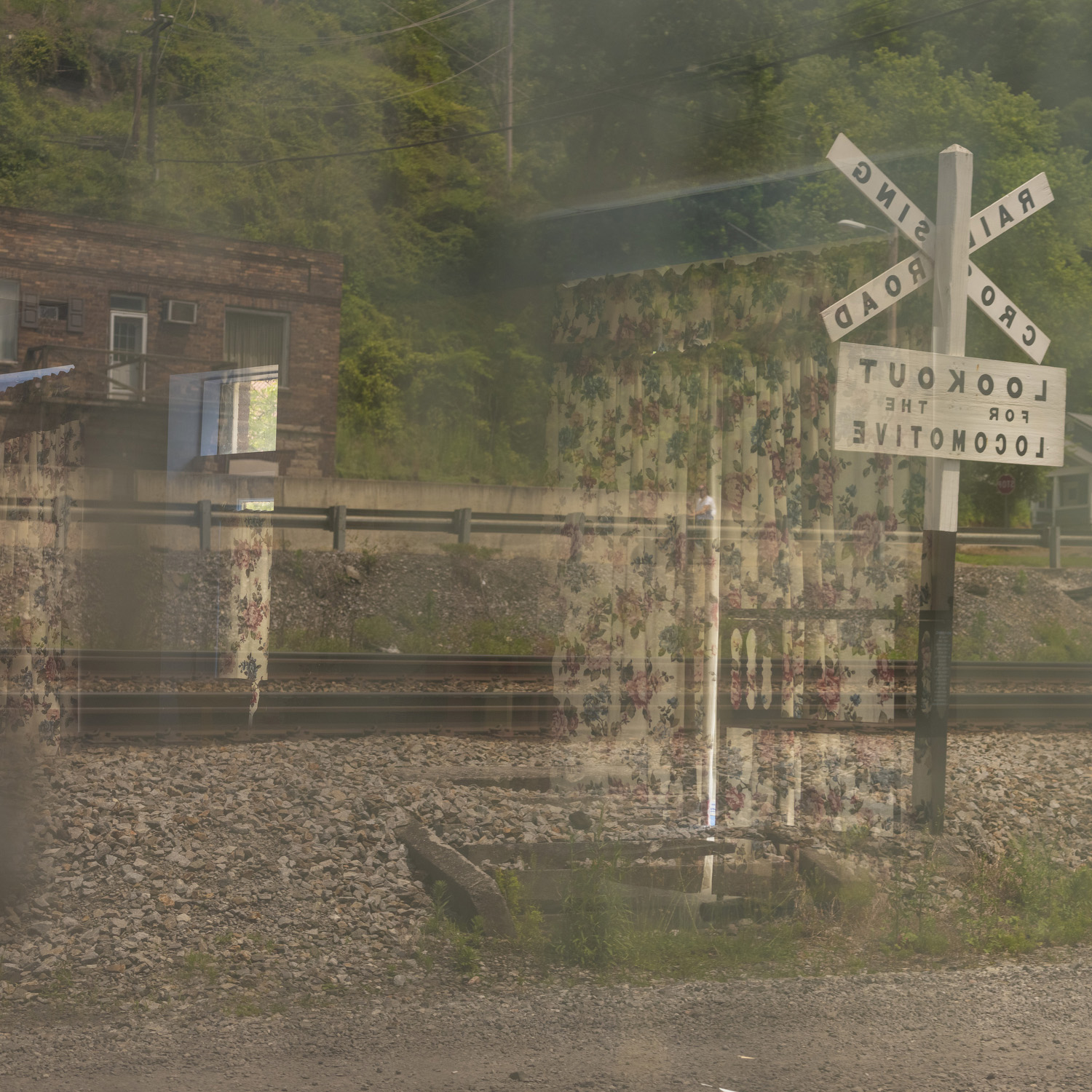 A double exposure of a curtain on a railroad crossing scene