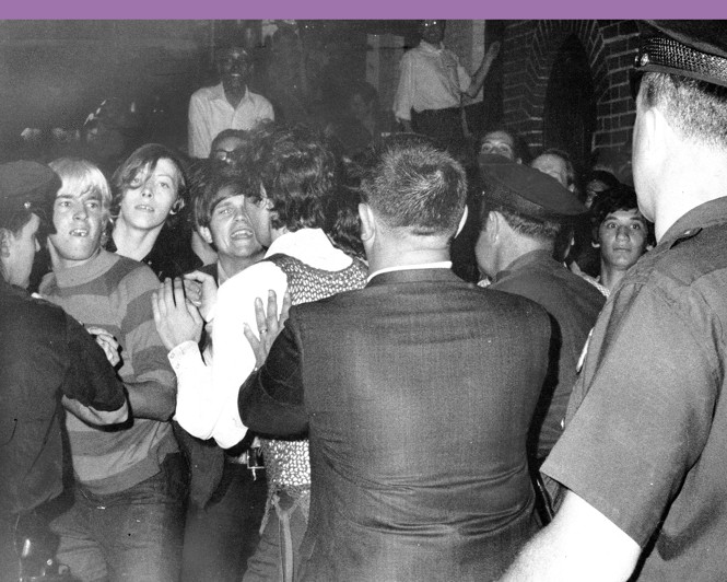 Police interact with a crowd of young men