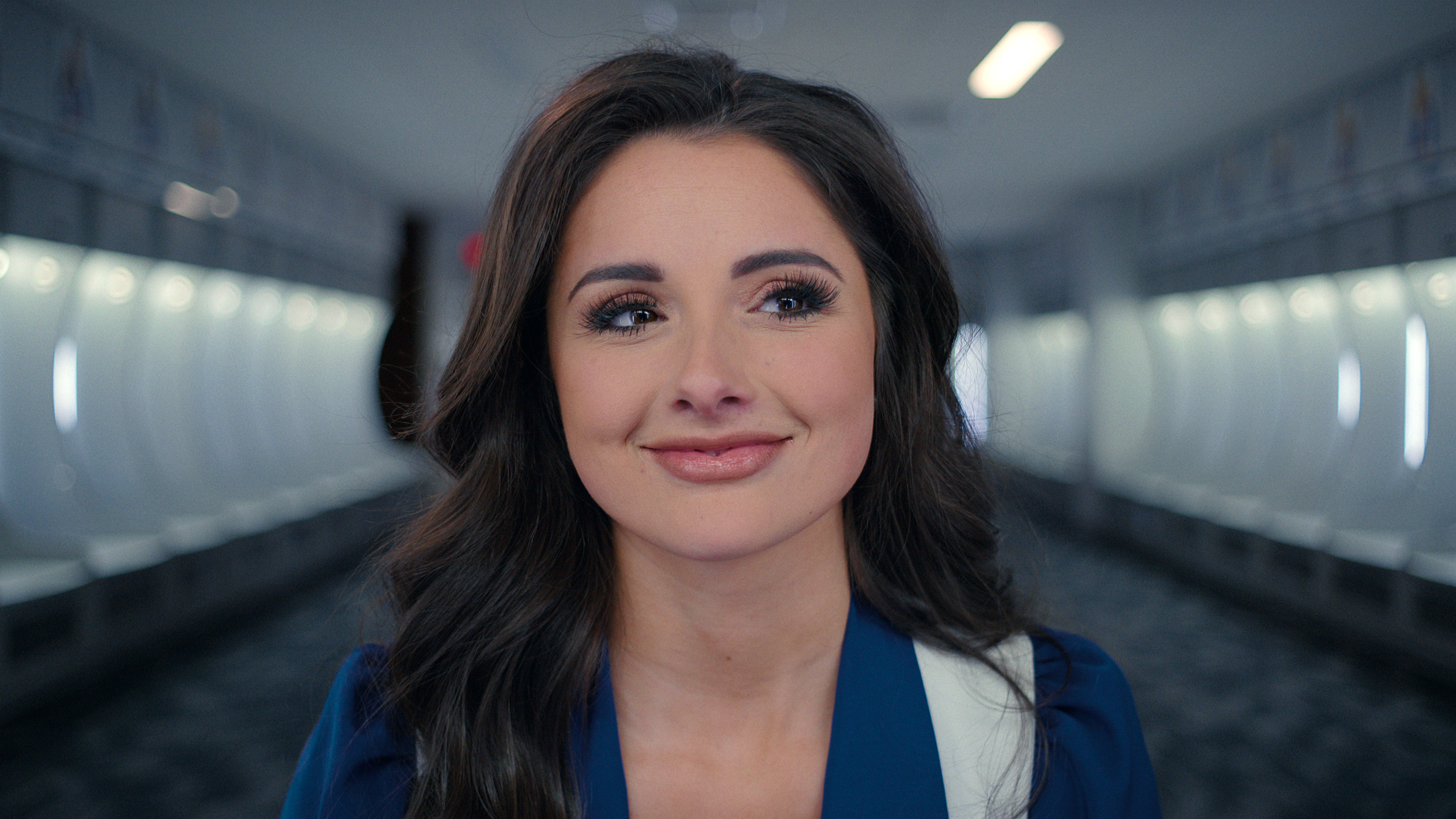 A brunette Dallas Cowboys cheerleader smiles and looks off to the side