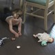 A photograph of children on and around a dining-room table, making a mess