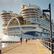 photo of Icon of the Seas, taken on a long railed path approaching the stern of the ship, with people walking along dock