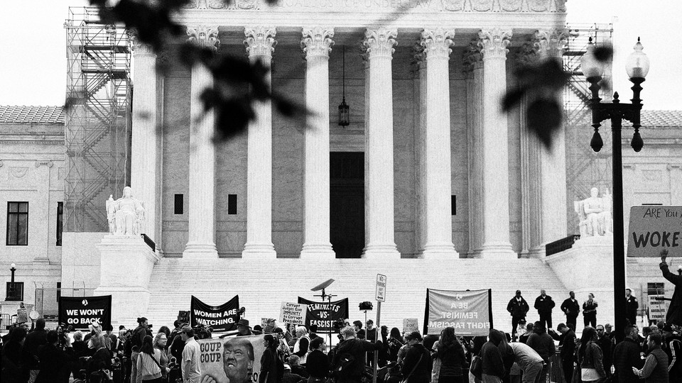 A black-and-white photo of protesters outside the entrance of the Supreme Court Building