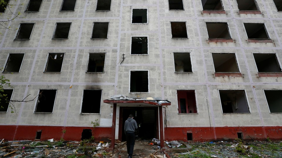 A worker passes a building, which is part of the old five-story apartment blocks demolition project launched by the city authorities, in Moscow, Russia.