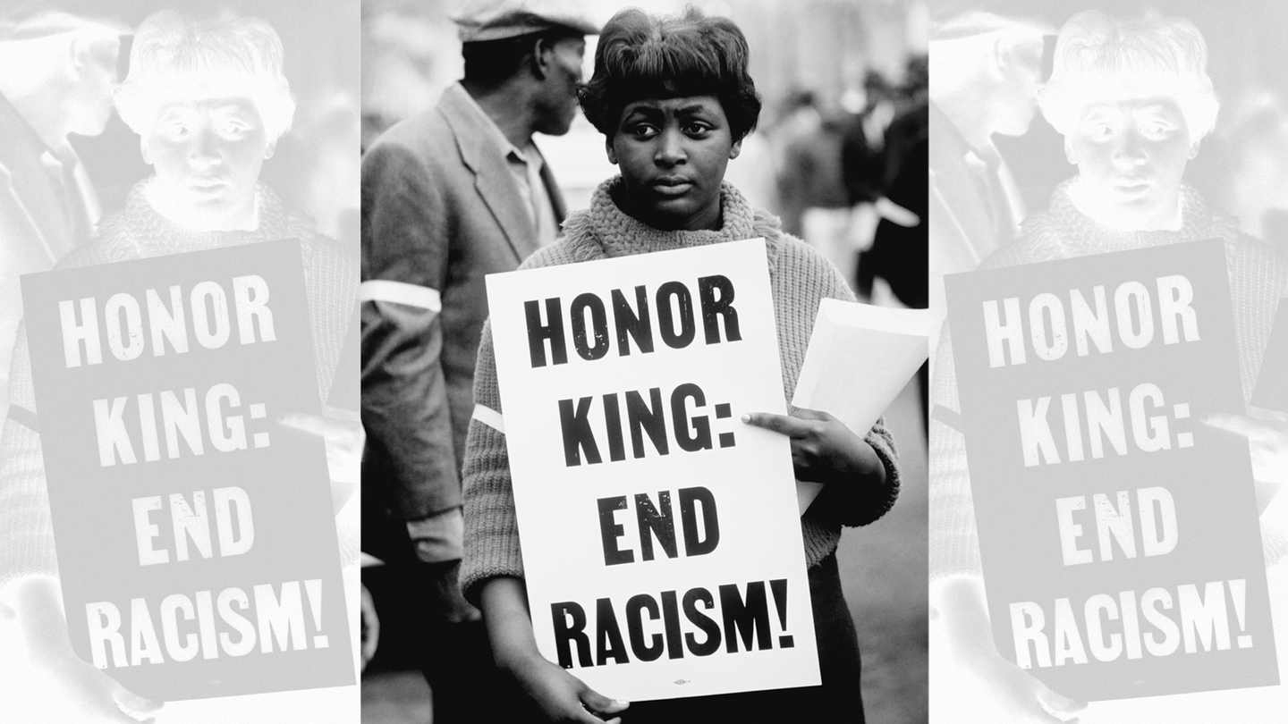 woman holding sign "Honor King: End Racism!"