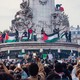 A pro-Palestinian protest including flags and signs encircles the statue at the center of Place de la Republique, in Paris.