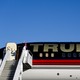 Trump waves standing next to his private plane that reads: TRUMP