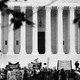 A black-and-white photo of protesters outside the entrance of the Supreme Court Building