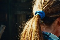 A girl, photographed from behind, wearing a blue-plaid flannel shirt