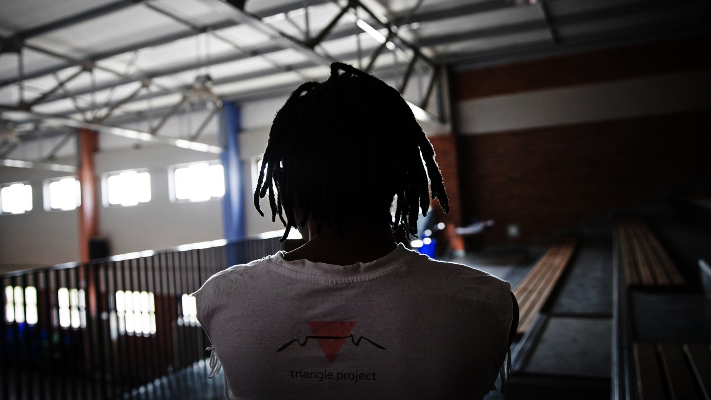 a silhouette of a figure wearing a t-shirt that says "Triangle Project"