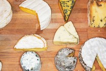 variety of cheese on a wooden board