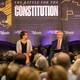 Four people sit on a stage in front of a sign that reads "The Battle for the Constitution"