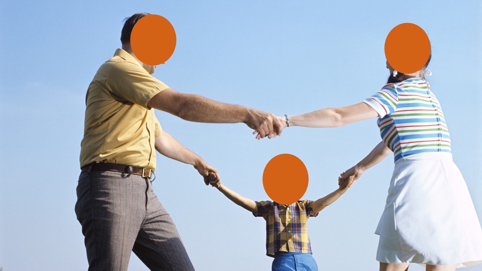 Two parents and one little kid hold hands in a circle, on a green field with a big blue sky in the background