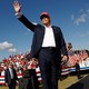 Trump wearing red hat, waving to crowd