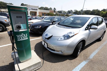 An electric vehicle at a Whole Foods–branded charging station