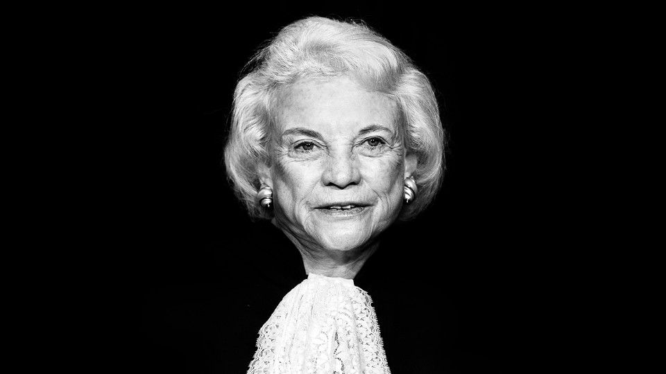 A black-and-white portrait of Sandra Day O’Connor, wearing her robes and facing the camera