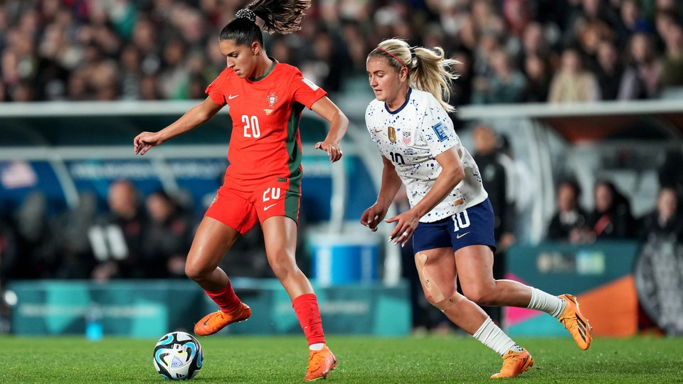 An American player chases a Portugese player at the Women's World Cup.