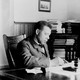 Booker T. Washington sits writing at his desk