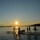 Young boys looking out over the water at sunset