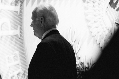 Black-and-white photo of Joe Biden standing in front of the presidential seal