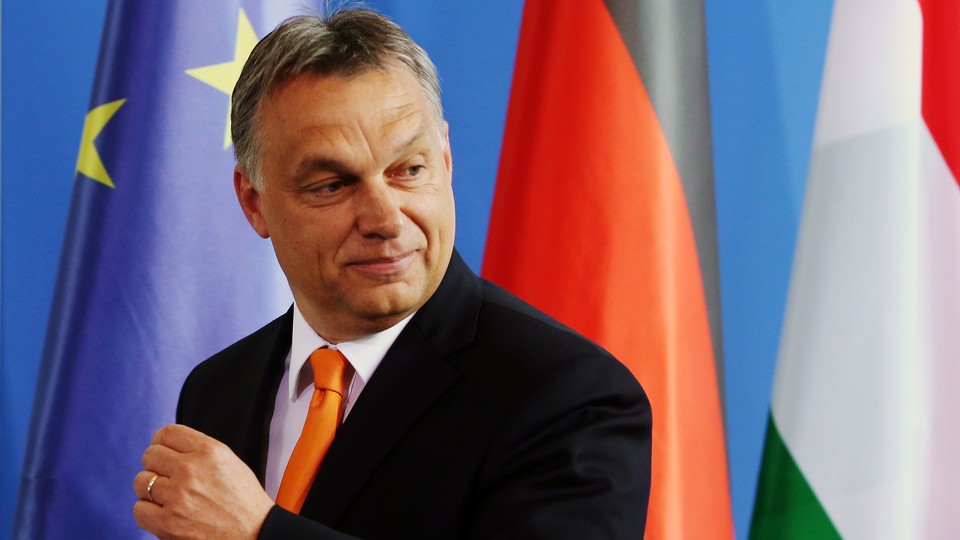 Hungarian Prime Minister Viktor Orbán stands in front of the European Union flag.